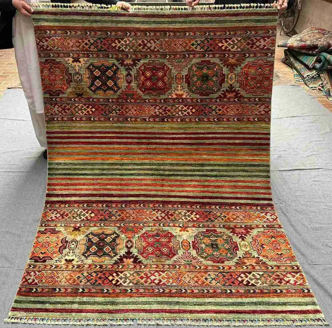 Full flat-lay of 5x7 handmade tribal red Khorjin wool rug