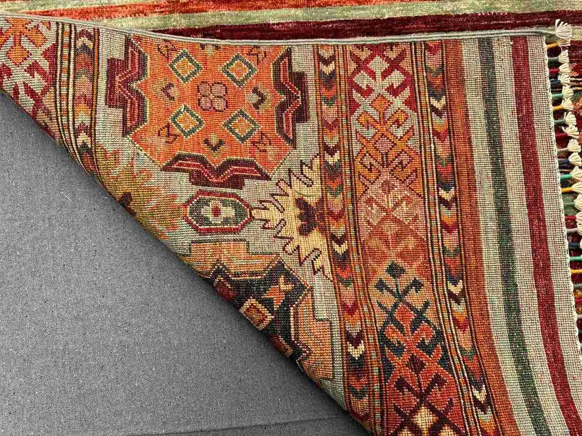 Folded backside of knotted tribal rug – wool and silk texture detail