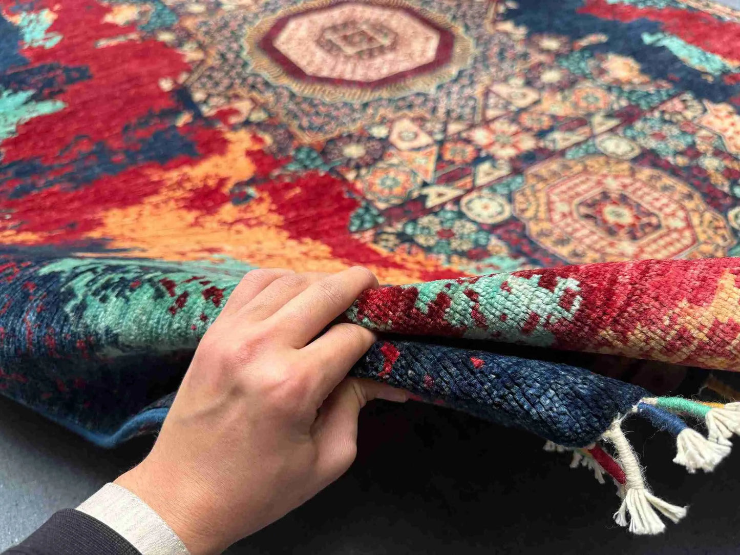 Hand-knotted 5x7 Persian-style oriental rug held to show quality craftsmanship
