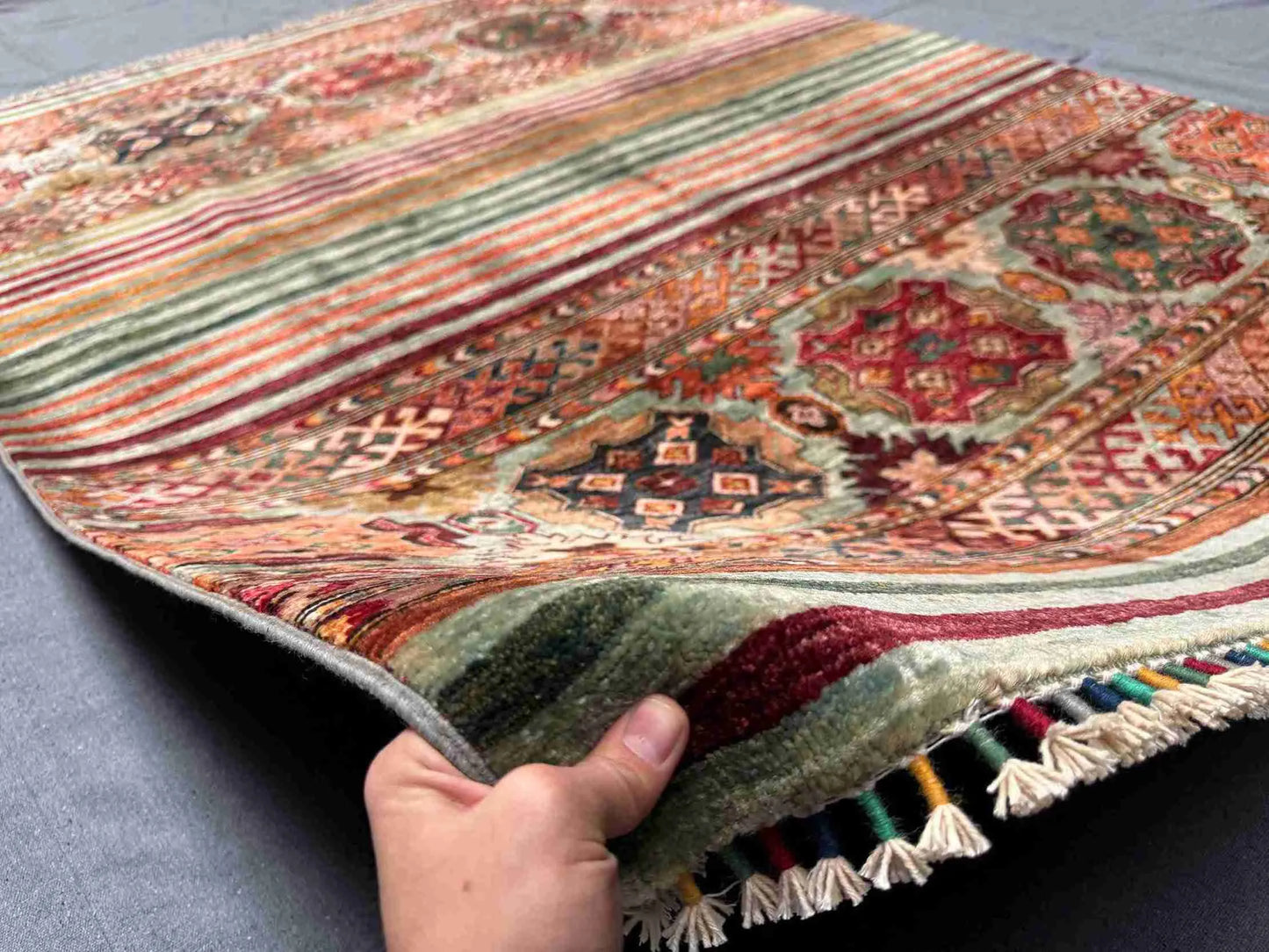 Handmade 5x7 Tribal Wool Rug in hands – front view of red Khorjin carpet