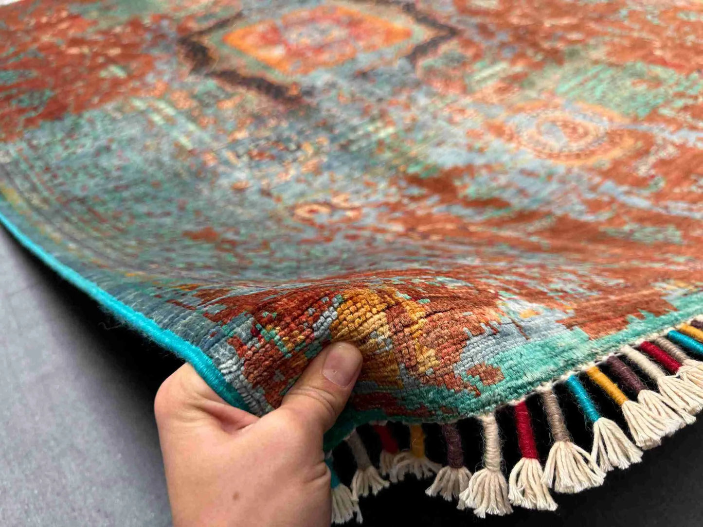 Front view of 5x8 multicolor Mamluk rug held by hand