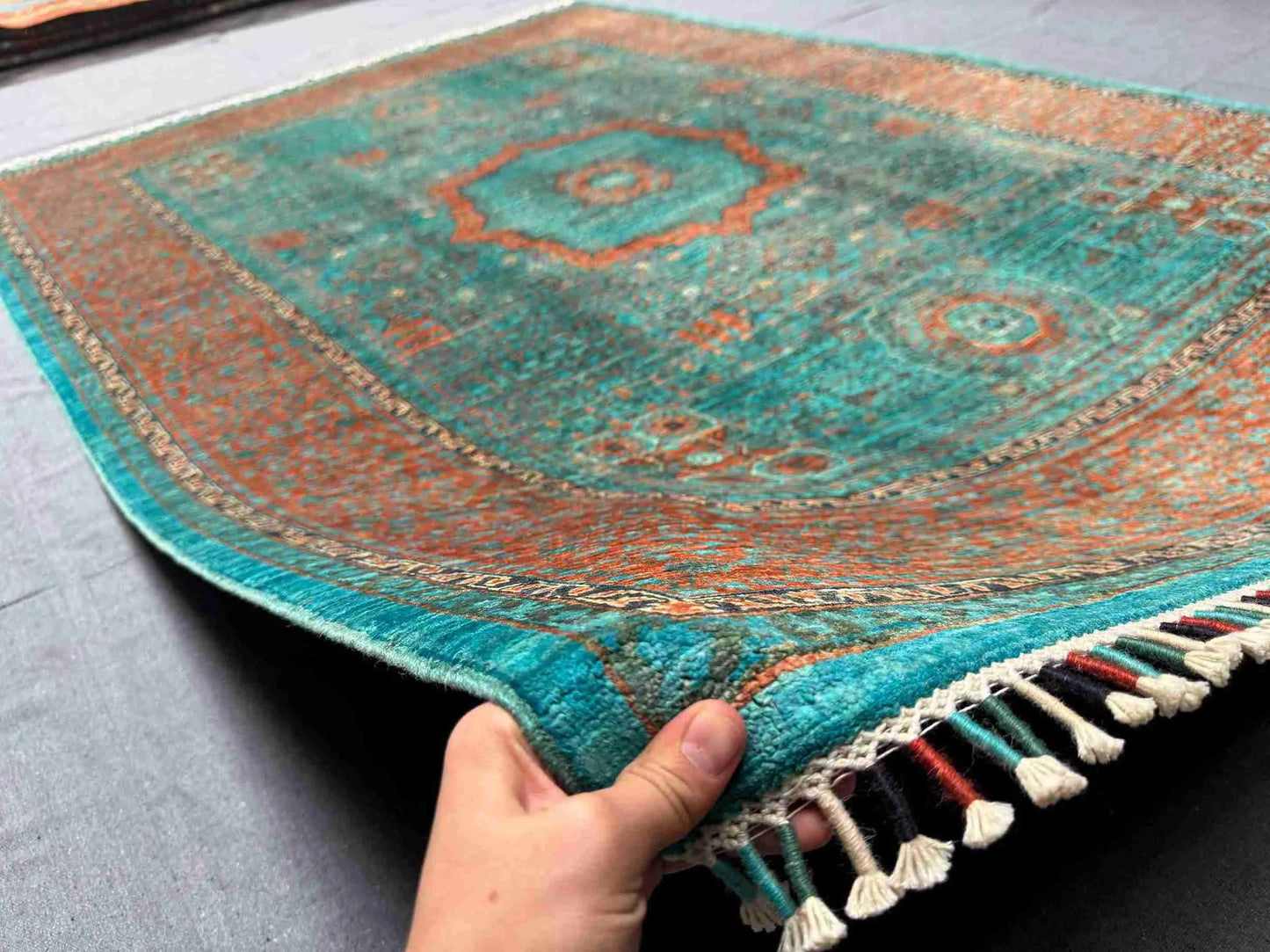 6x8 handmade Mamluk rug in hand showing vibrant green and orange wool texture