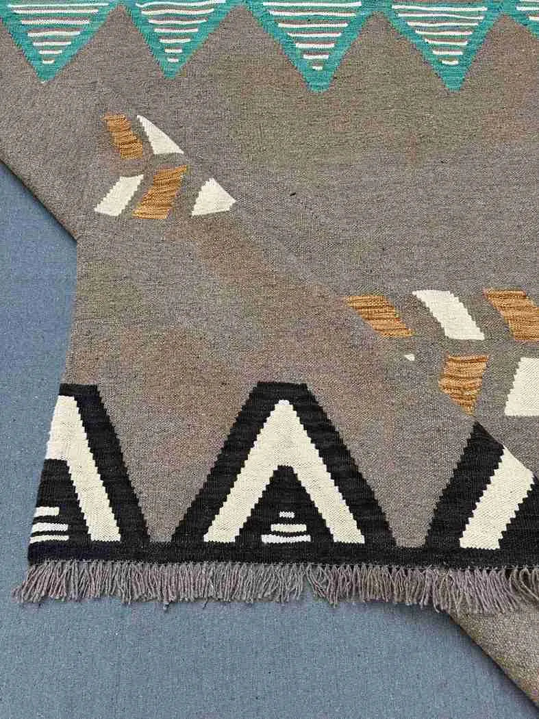 Folded front of 6x9 Kilim rug showing lightweight flatweave material.