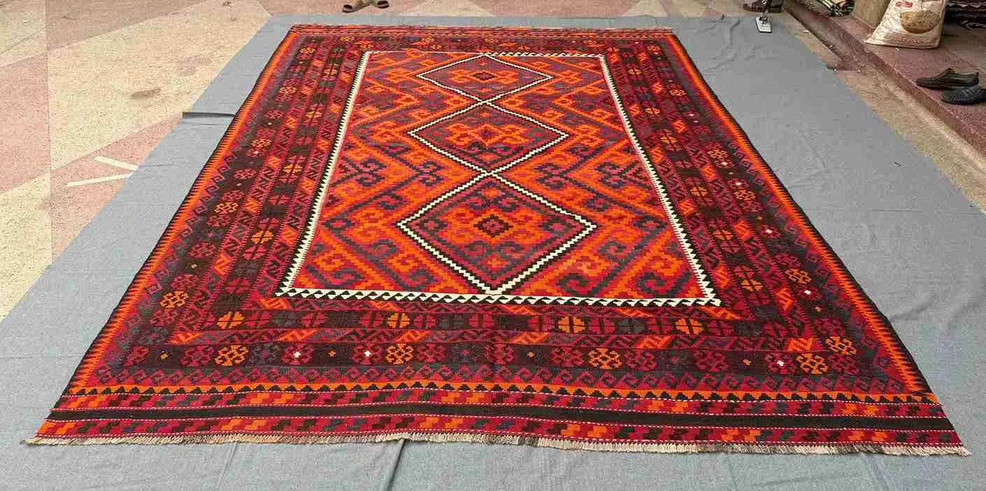 8x12 handwoven Kilim rug with geometric red and black pattern – Turkish tribal carpet on floor.