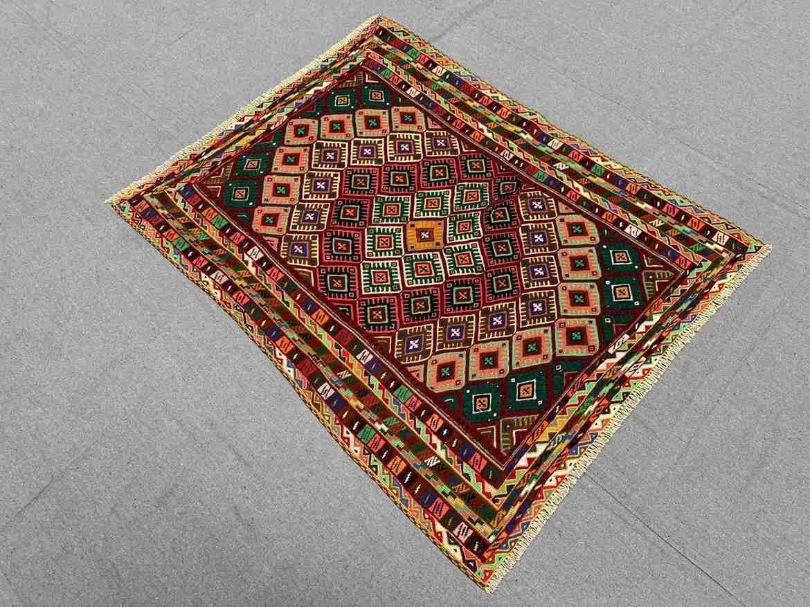 Flatweave Afghan rug in vintage interior with red and multicolor tones