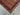 Close-up corner detail of handmade Afghan shawl rug – red and green tribal stripes.