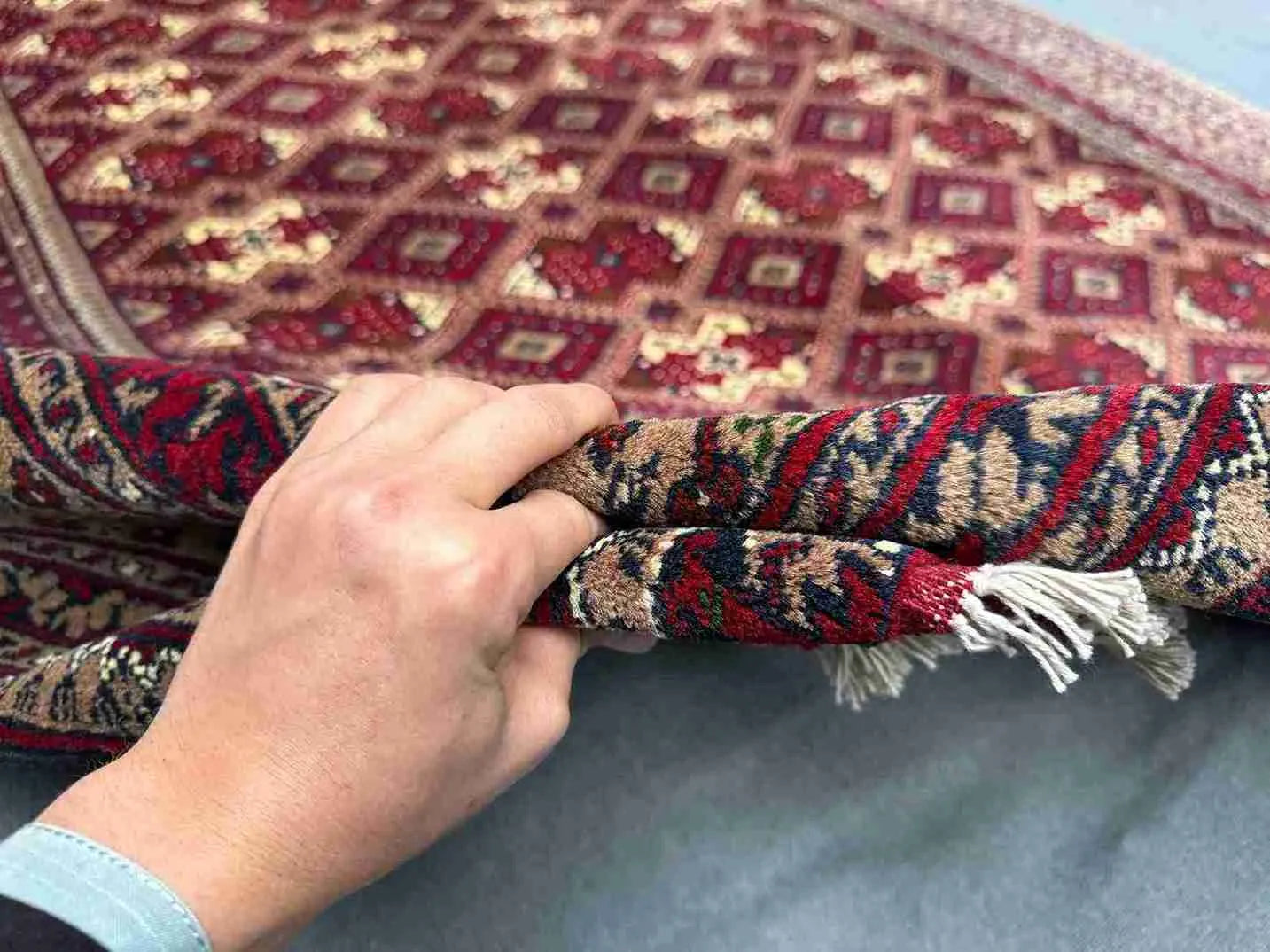 Authentic Turkish handmade rug showing knotted wool silk texture in hand