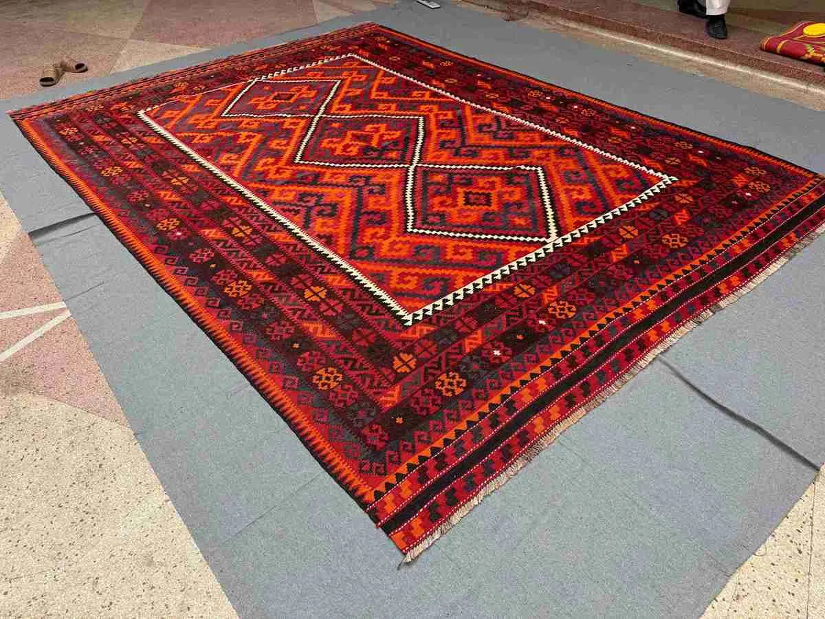 Boho interior floor decor featuring vintage red and black Turkish Kilim rug – wool flatweave.