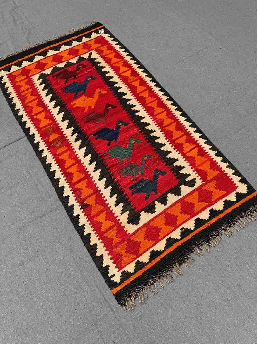Boho interior with red and orange Turkish Kilim rug – handmade wool flatweave on floor