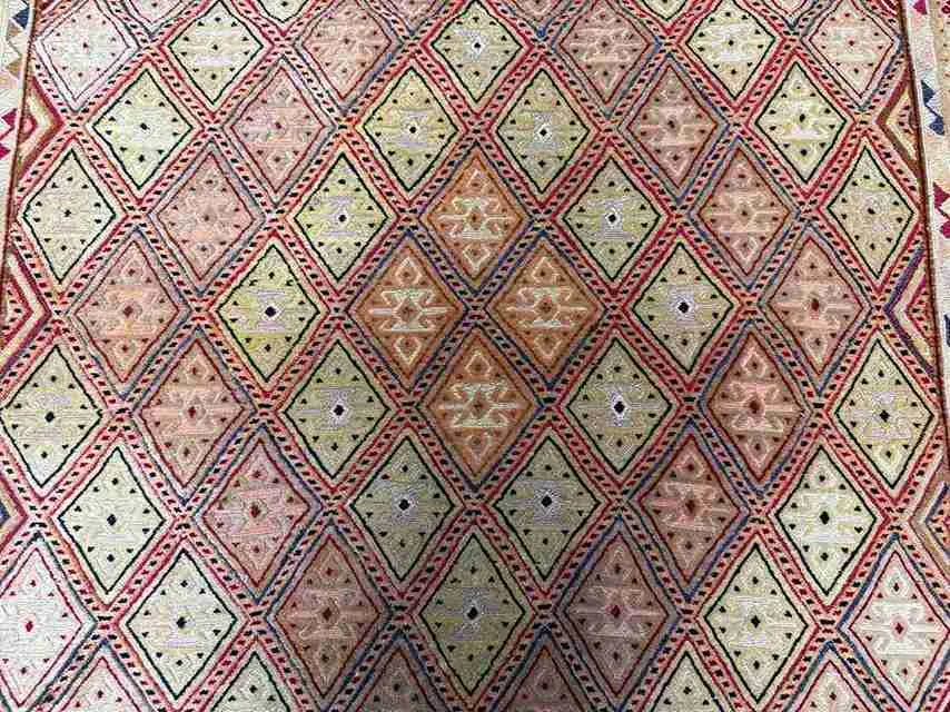 Close-up of beige and gold tribal pattern on vintage Afghan Turkish wool rug