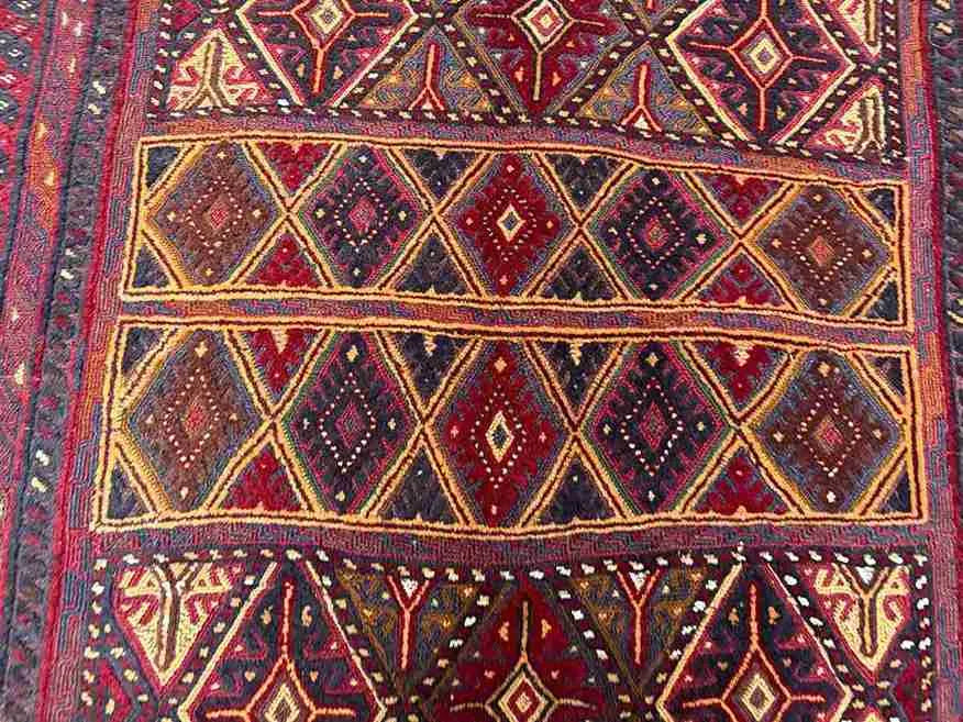 Color detail in dark red, gold, and brown on oriental tribal carpet