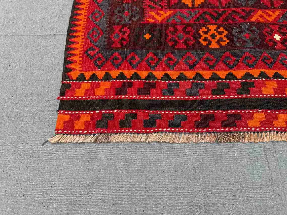 Corner detail of red and black geometric Kilim rug – traditional Turkish hand-knotted wool flatweave.