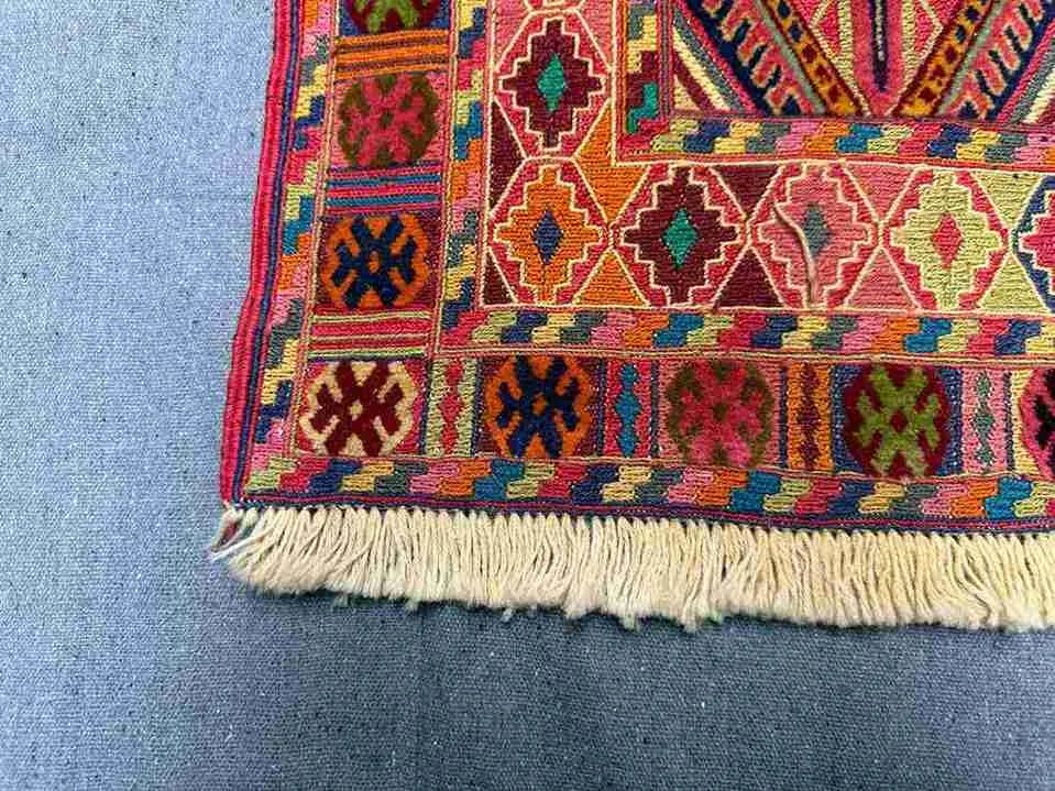 Corner close-up of antique kilim rug showing intricate tribal design