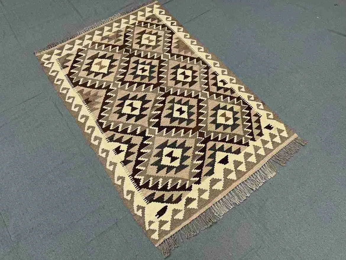 Floor view of earthy-tone flatweave Kilim rug – boho tribal wool carpet.