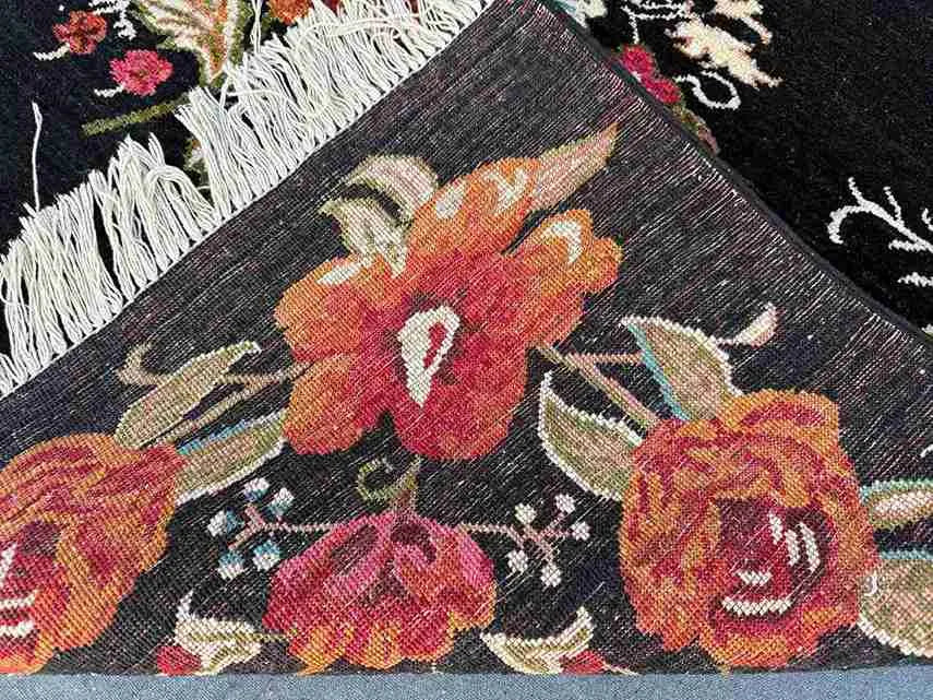 Folded Karabakh rug showing wool texture and floral edge pattern