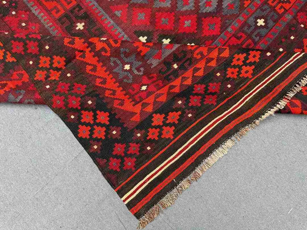 Folded 8x12 vintage Turkish Kilim rug – red and black wool flatweave with tribal oriental design.