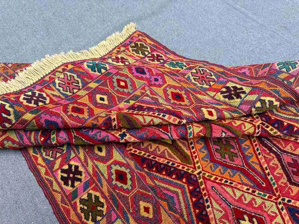 Side view of folded Turkish handmade kilim rug showing thickness