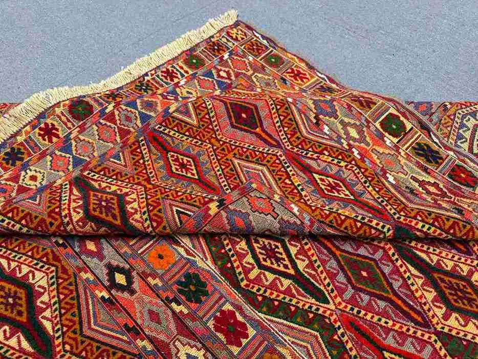 Side view of folded tribal kilim rug showing wool construction and vibrant colors