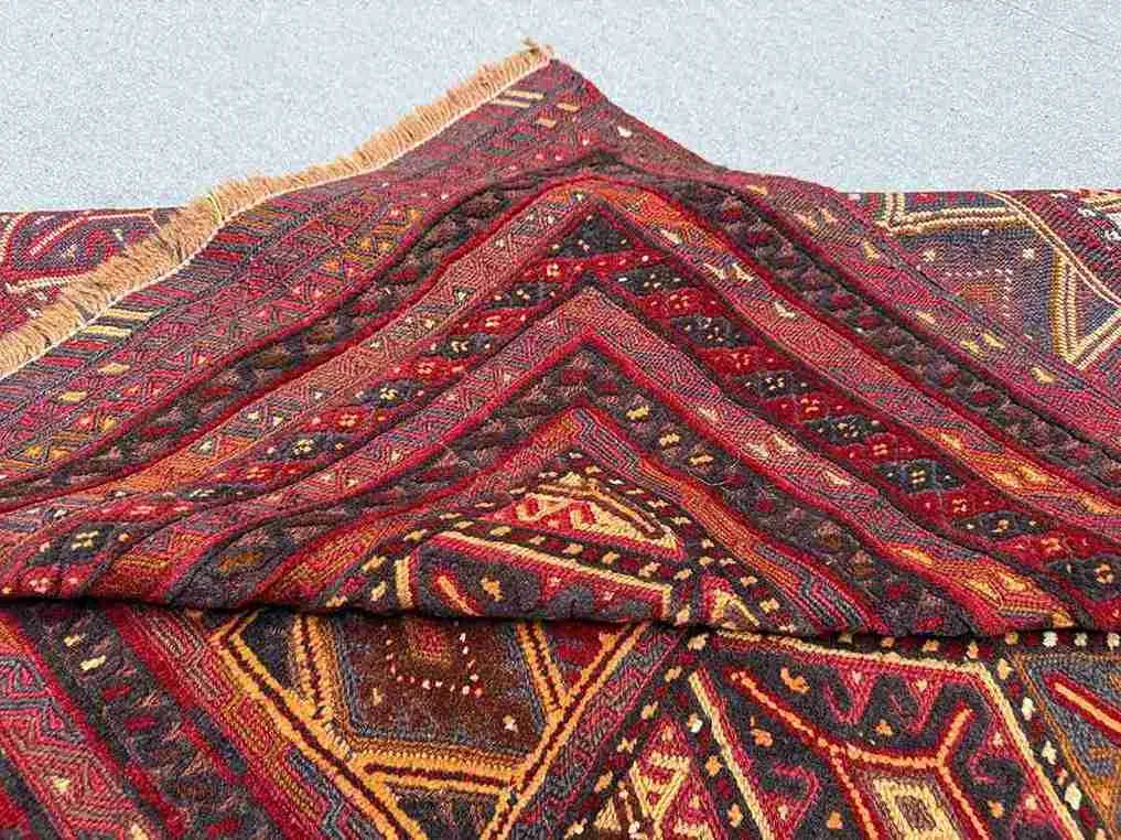 Folded side view of 3.10x4.3 Turkish Afghan kilim rug showing wool edges