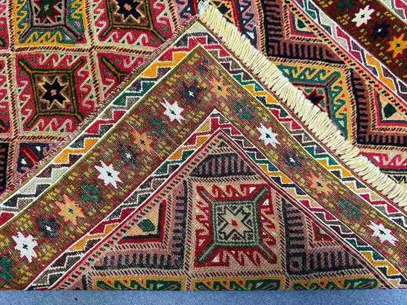 Folded side view of Turkish Afghan runner rug showing woven wool edges
