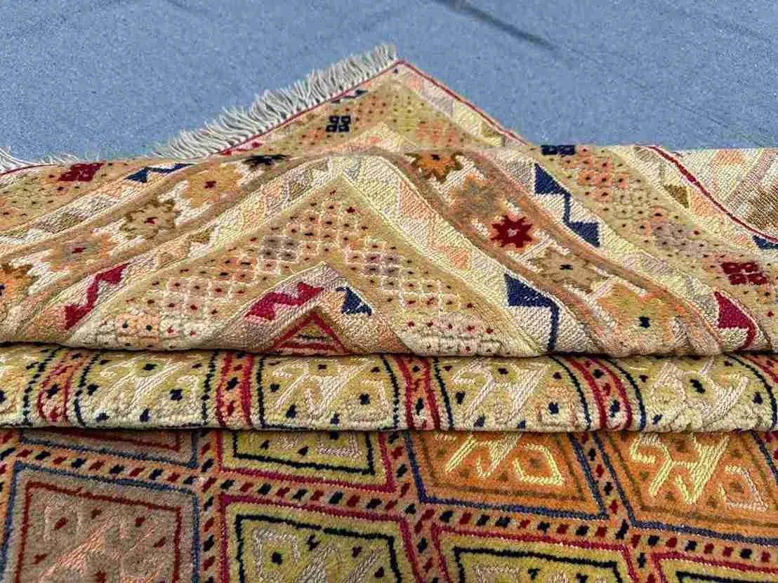 Folded side view of Afghan Turkish wool rug showing edge detail and weave