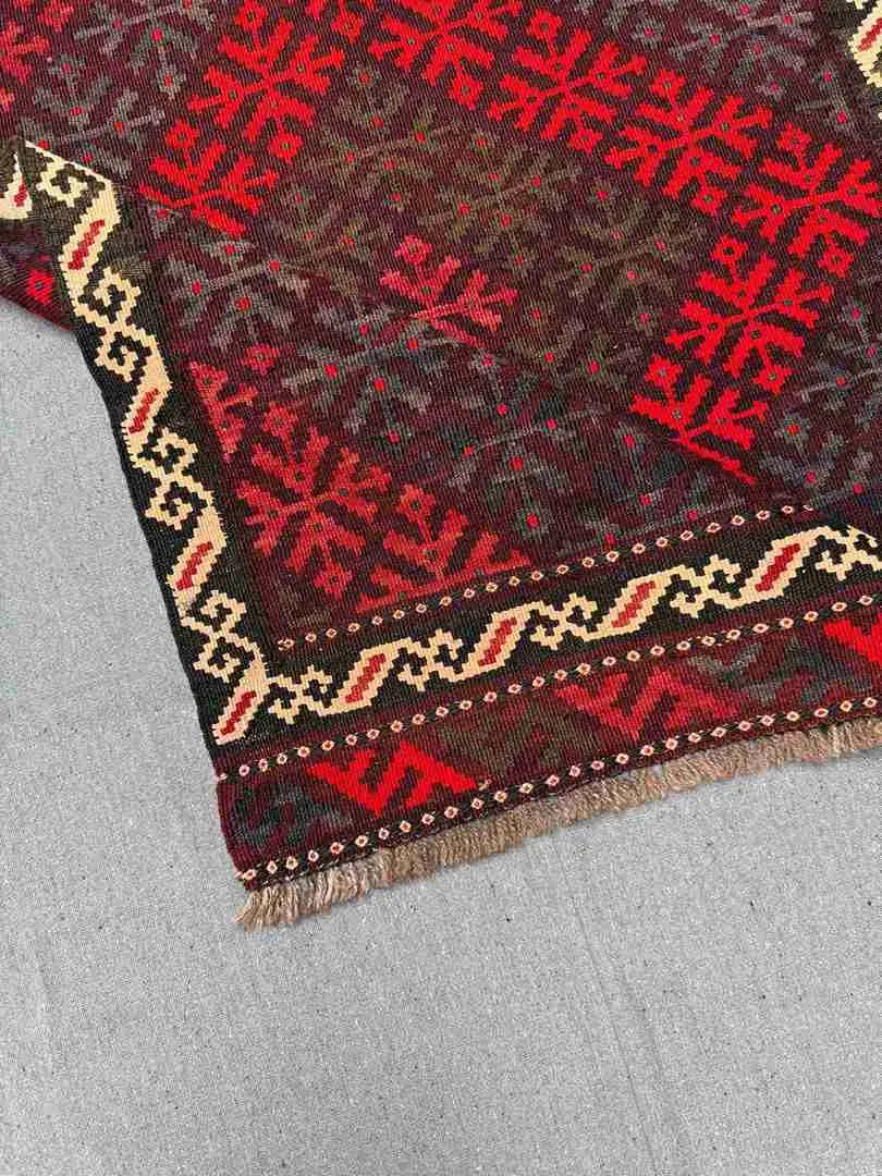 Folded view of vintage Afghan Kilim rug – vibrant red small wool flatweave ideal for gifting.
