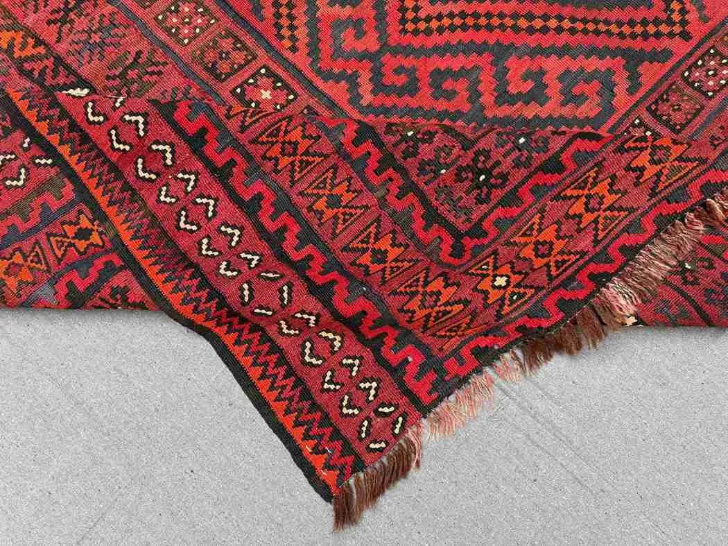 Folded view of vintage Turkish Kilim rug – red and black wool flatweave in 8x13 size.