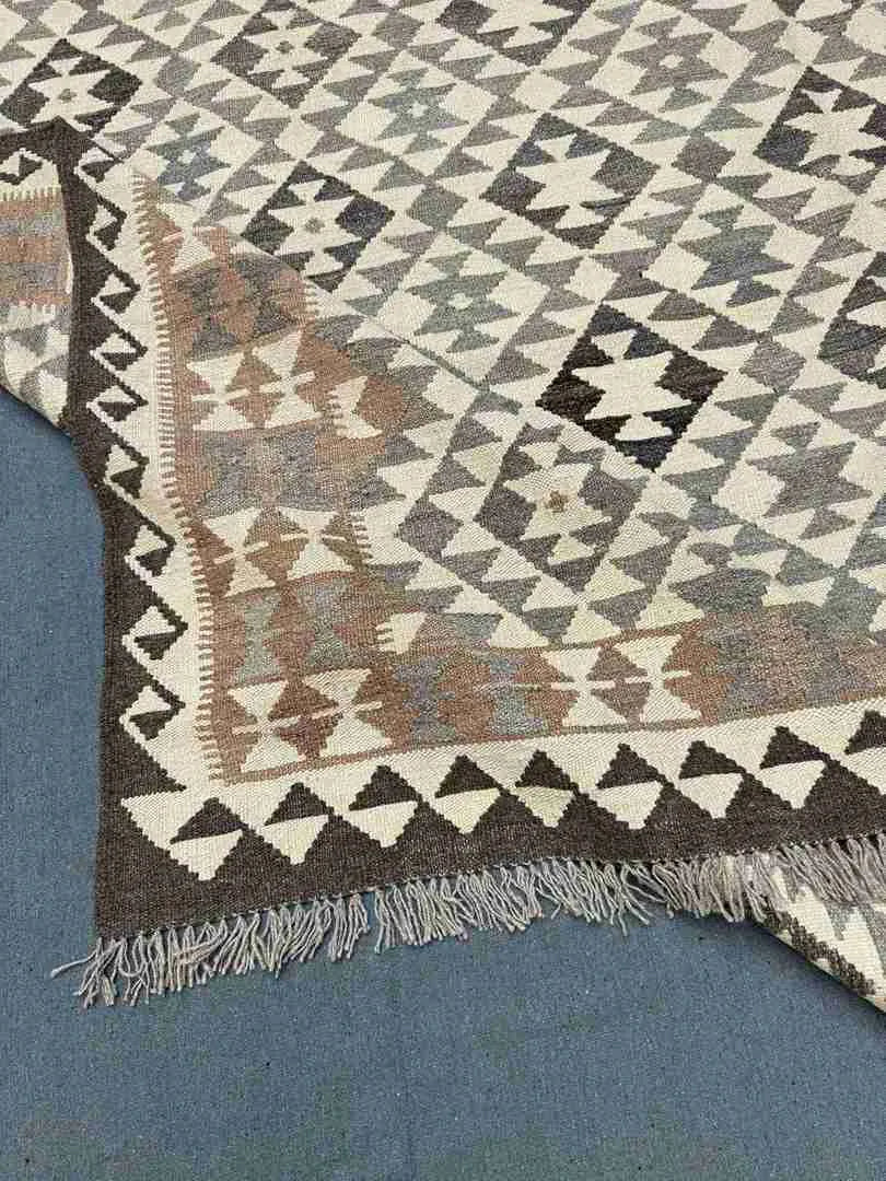 Folded view of wool Kilim rug – 8x10 Turkish handmade piece with earthy and vibrant pattern.