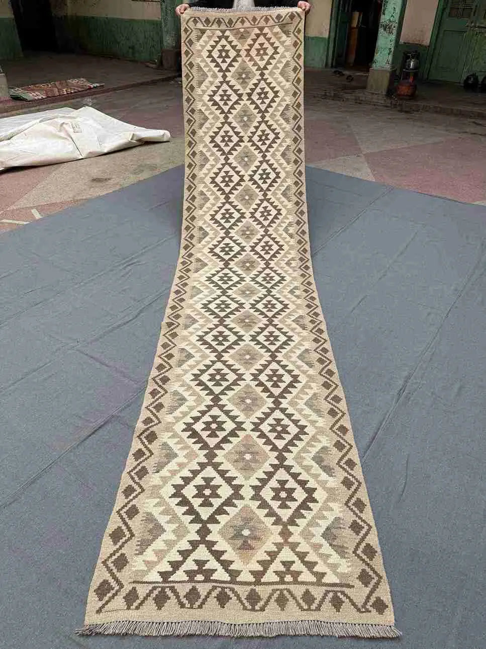 Full view of handmade beige and brown kilim runner rug