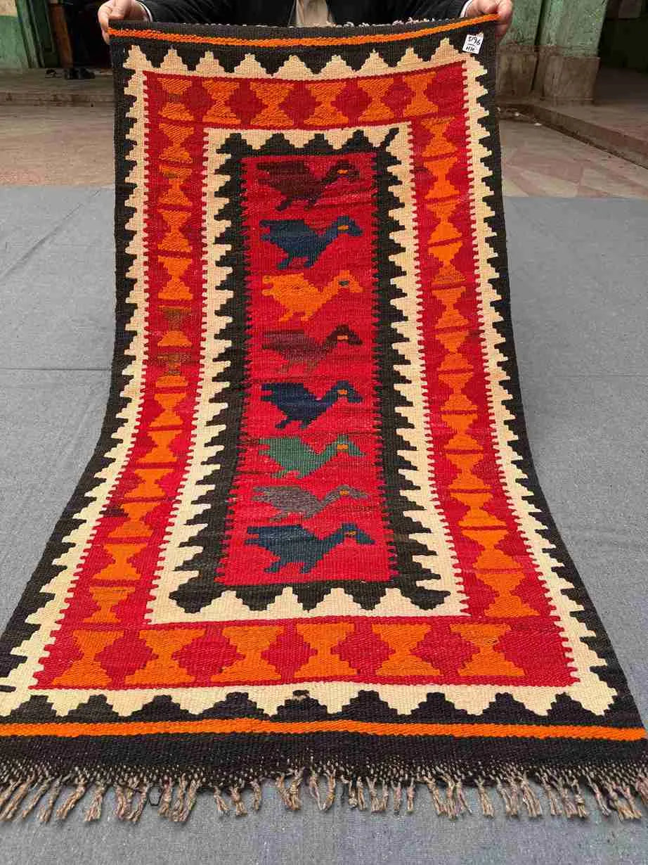 Full view of handmade vintage Turkish Kilim rug – red and orange tribal wool flatweave in boho style.
