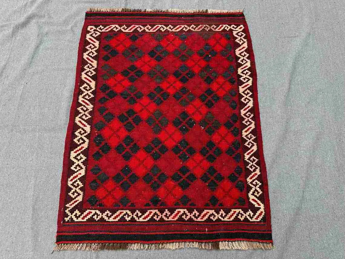 Floor setup with geometric Afghan Kilim rug – small red wool carpet perfect for boho spaces.