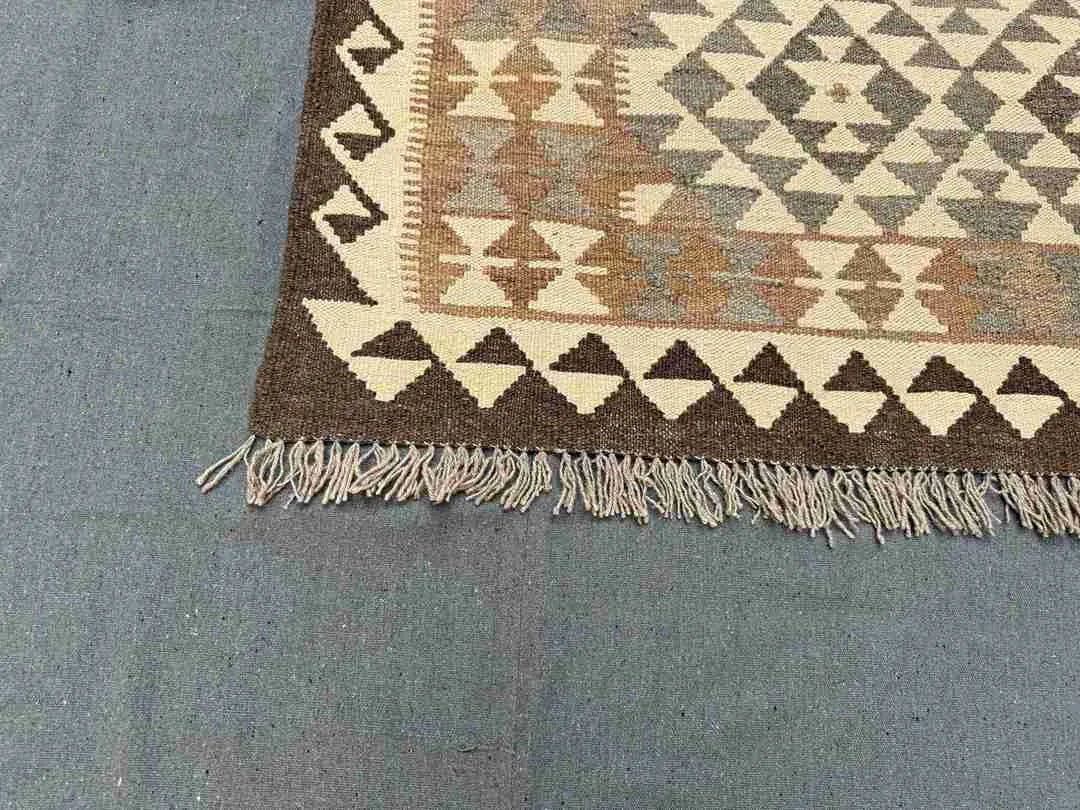 Corner detail of geometric Turkish Kilim rug – wool flatweave with vibrant and neutral color accents.