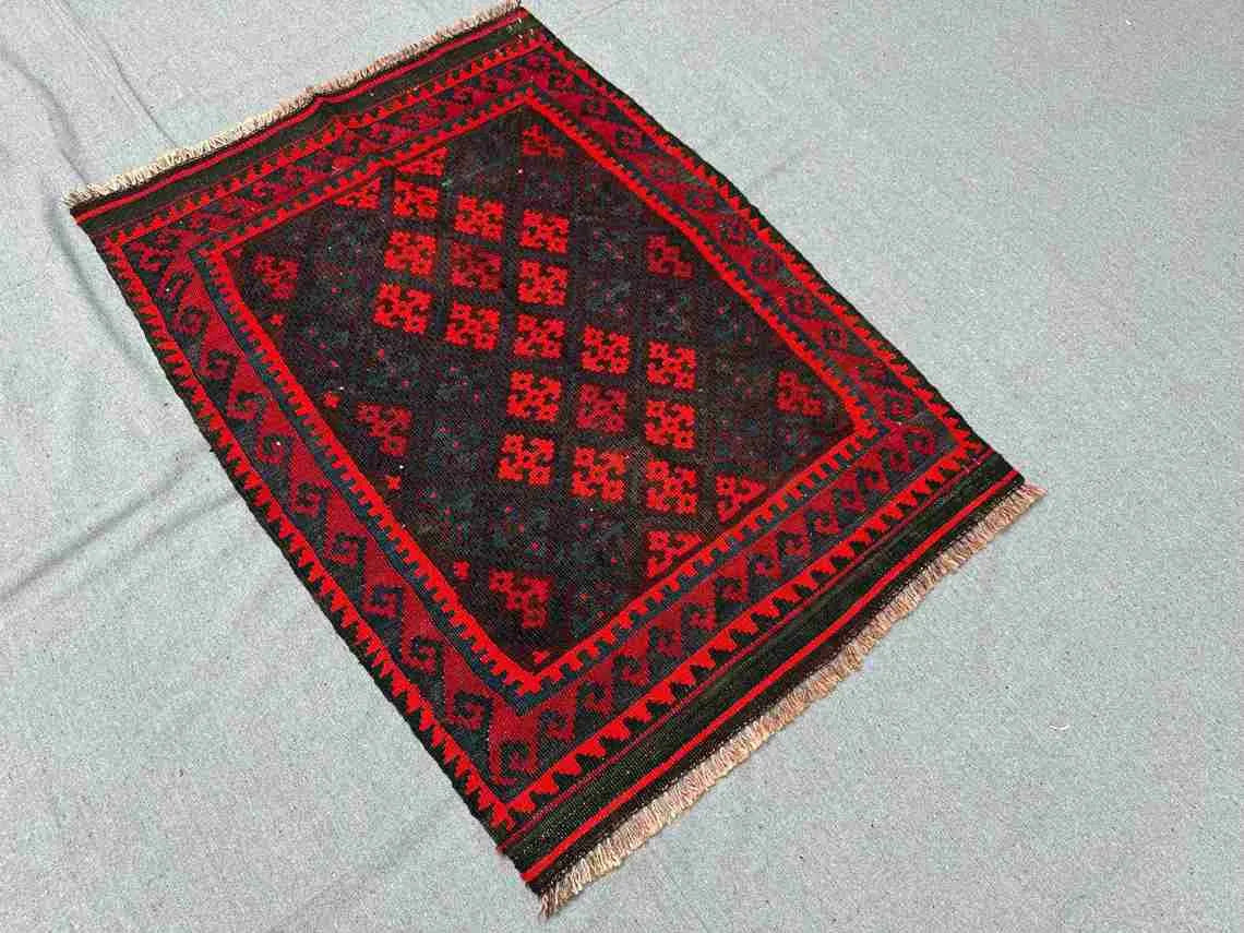 Floor view of small geometric Kilim rug – tribal red tones and handwoven wool texture.