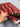 Hand-knotted 3x5 Afghan tribal rug in hand with visible red wool texture