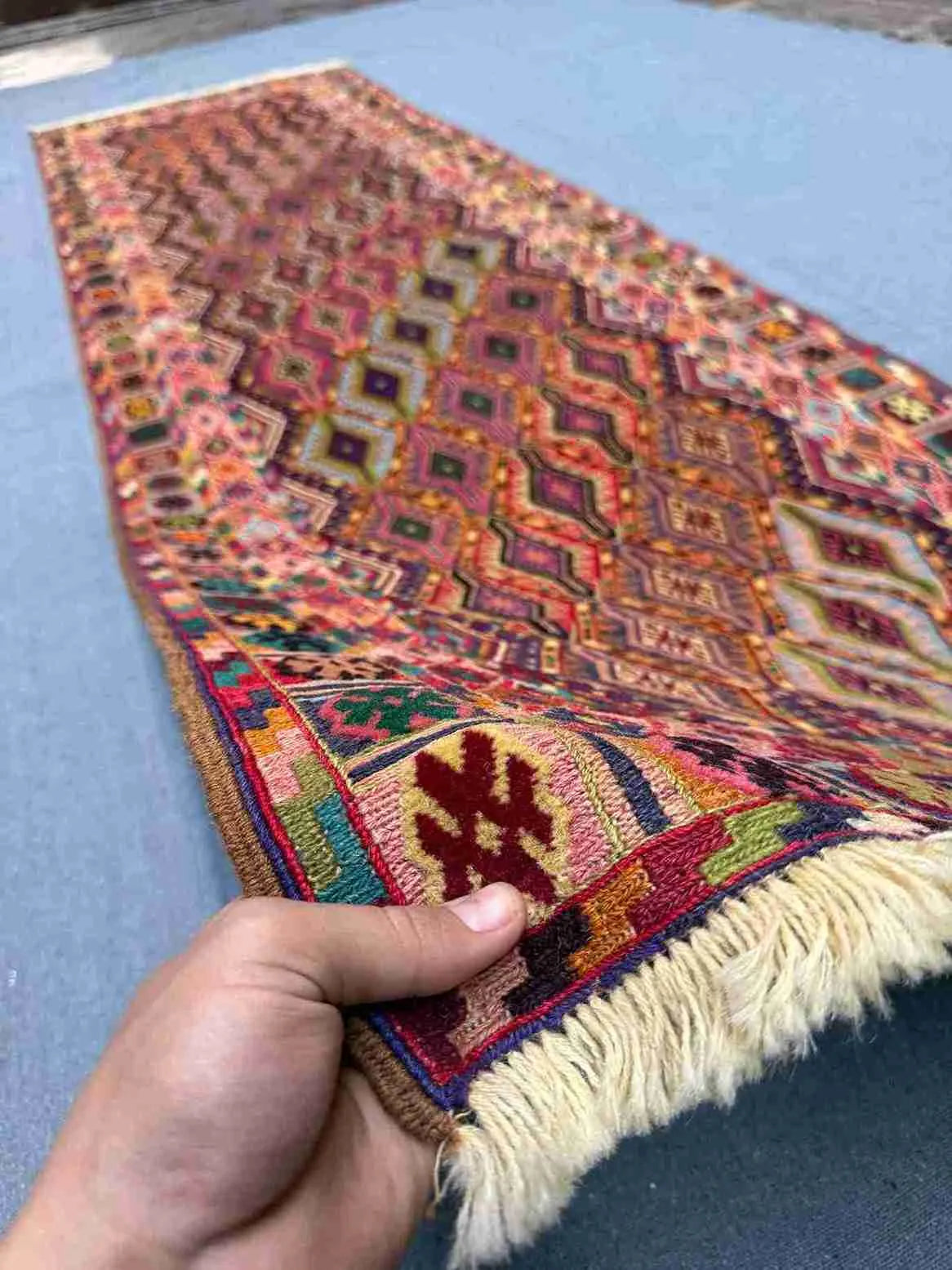Person holding antique 2.8x9.3 Turkish kilim runner rug – geometric tribal wool carpet