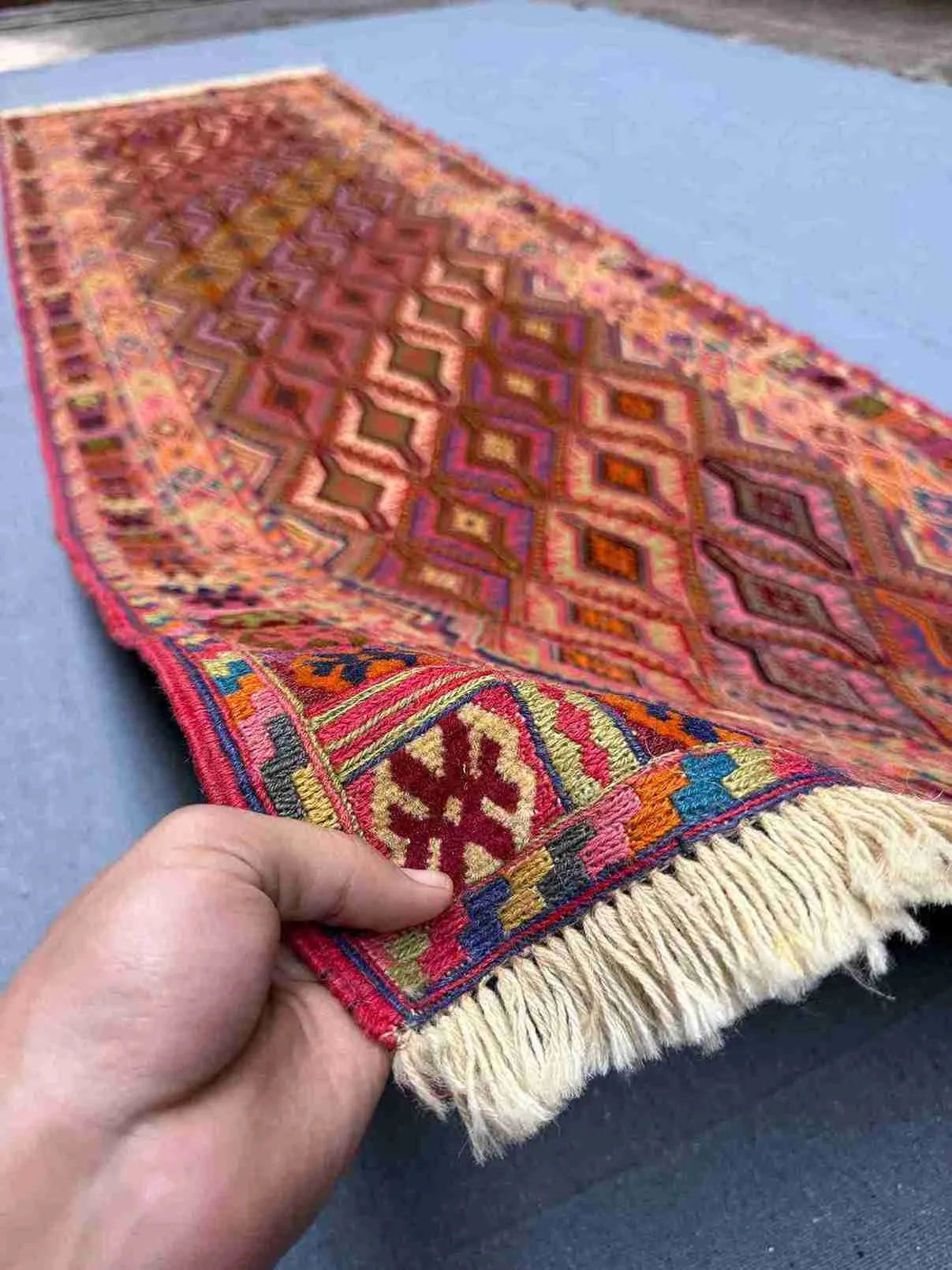 Handwoven Turkish kilim runner rug held to show soft wool and tribal design