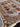 In-hand view of authentic handmade Turkish blue and red wool carpet with floral pattern