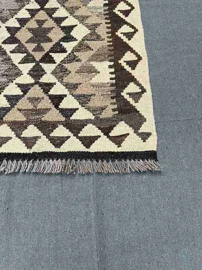 Corner detailing of handmade beige and brown Kilim rug