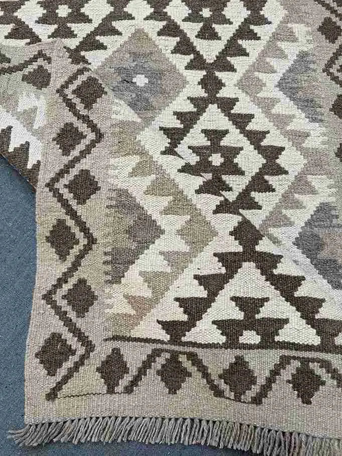 Folded handmade kilim rug in beige and brown tones
