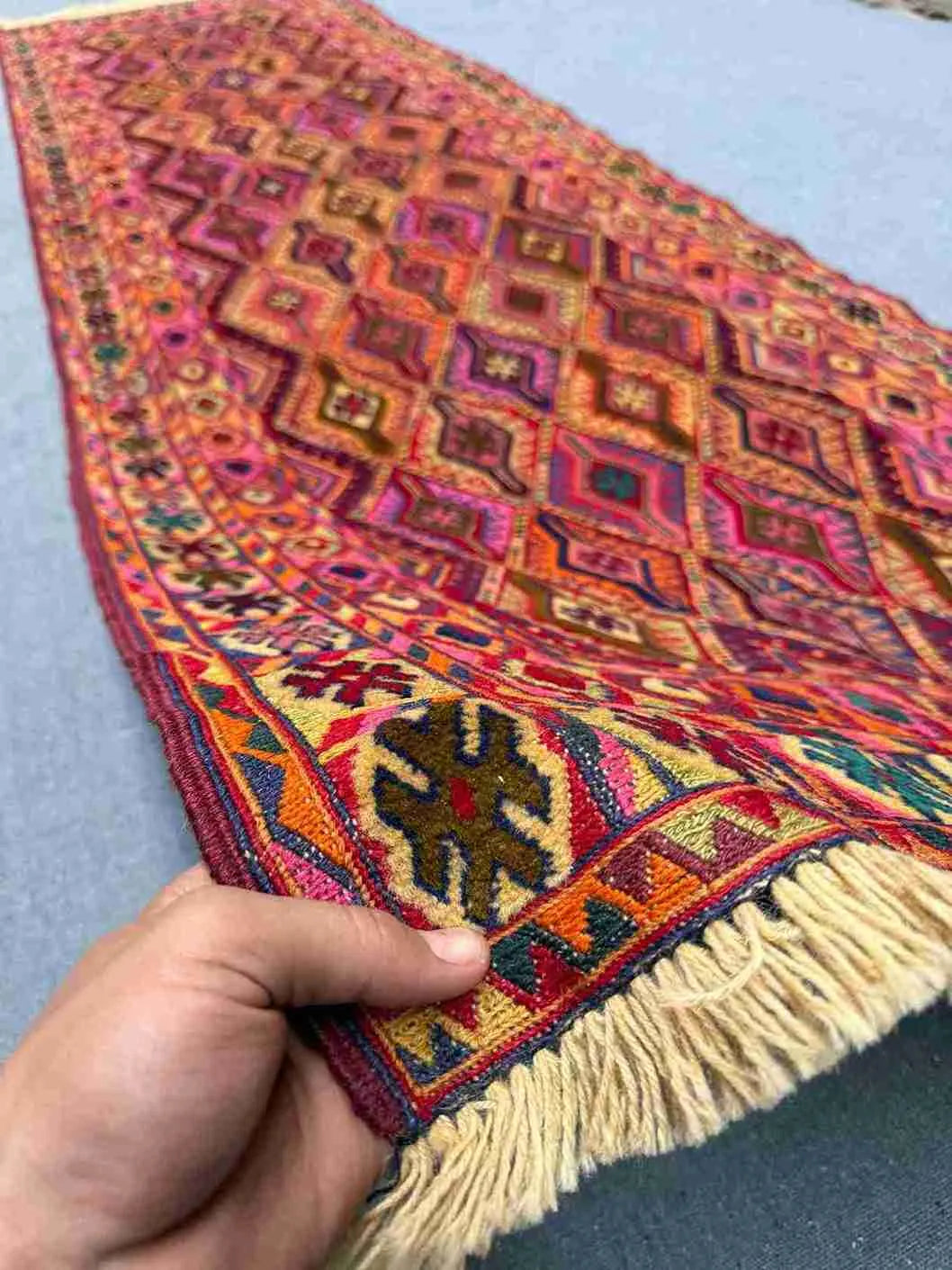 Handheld view of 2.9x9.3 Turkish handmade kilim runner with tribal pattern