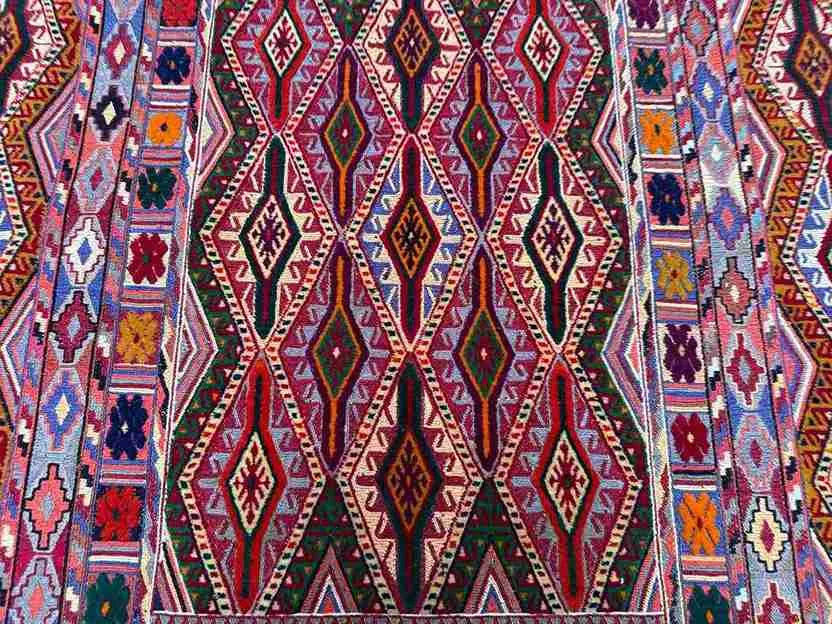 Detailed multicolor tribal pattern on handwoven Turkish kilim wool carpet