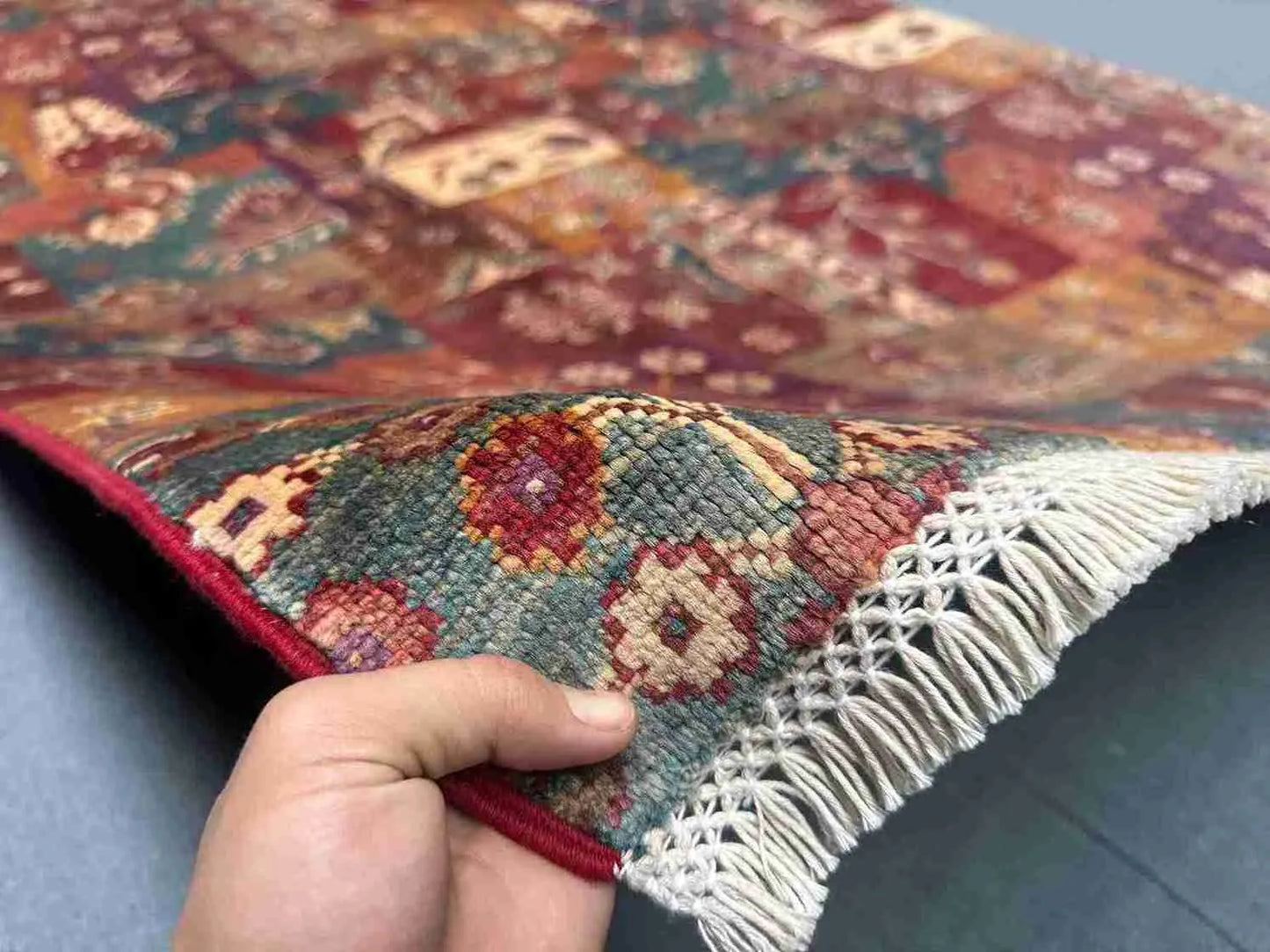 Handmade vintage wool patchwork kilim held in hand with tribal design