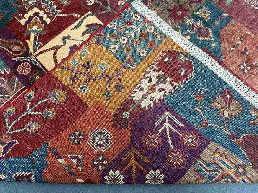 Folded edge and texture detail of colorful Persian-style patchwork rug