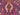 Close-up of tribal geometric patterns on Turkish Kilim rug in pink, blue, and green