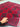 Handmade Red Kalisa wool rug held to show softness and texture