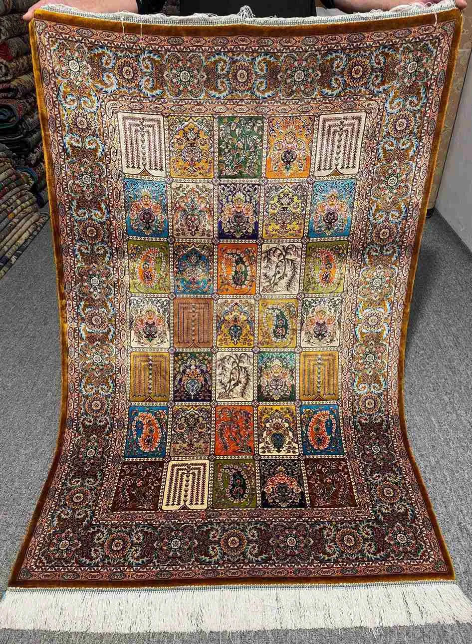 Full top-down view of Persian-style silk patchwork rug