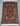 Traditional knotted Persian silk rug on wood flooring with classic motif