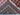 Corner fold showing knotting and wool layers of red tribal rug