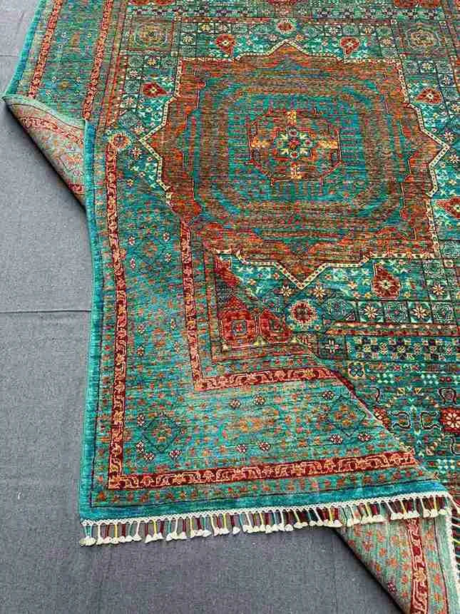 Folded vibrant Mamluk carpet showing fine wool weave and rich tones