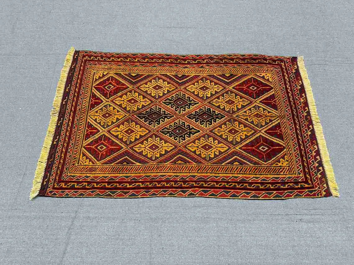 Vintage red and gold kilim rug in home floor layout